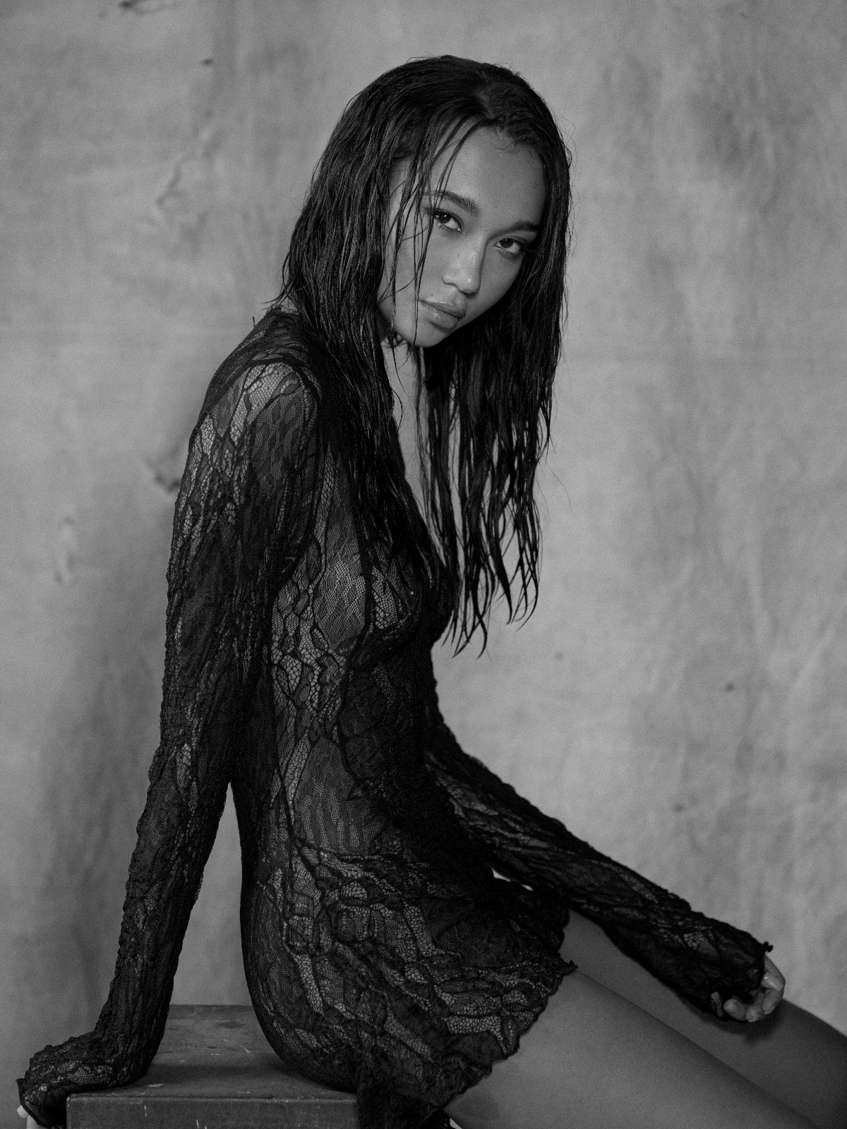 Modella in pizzo nero, look elegante e sensuale, fotografata in bianco e nero per la moda contemporanea.