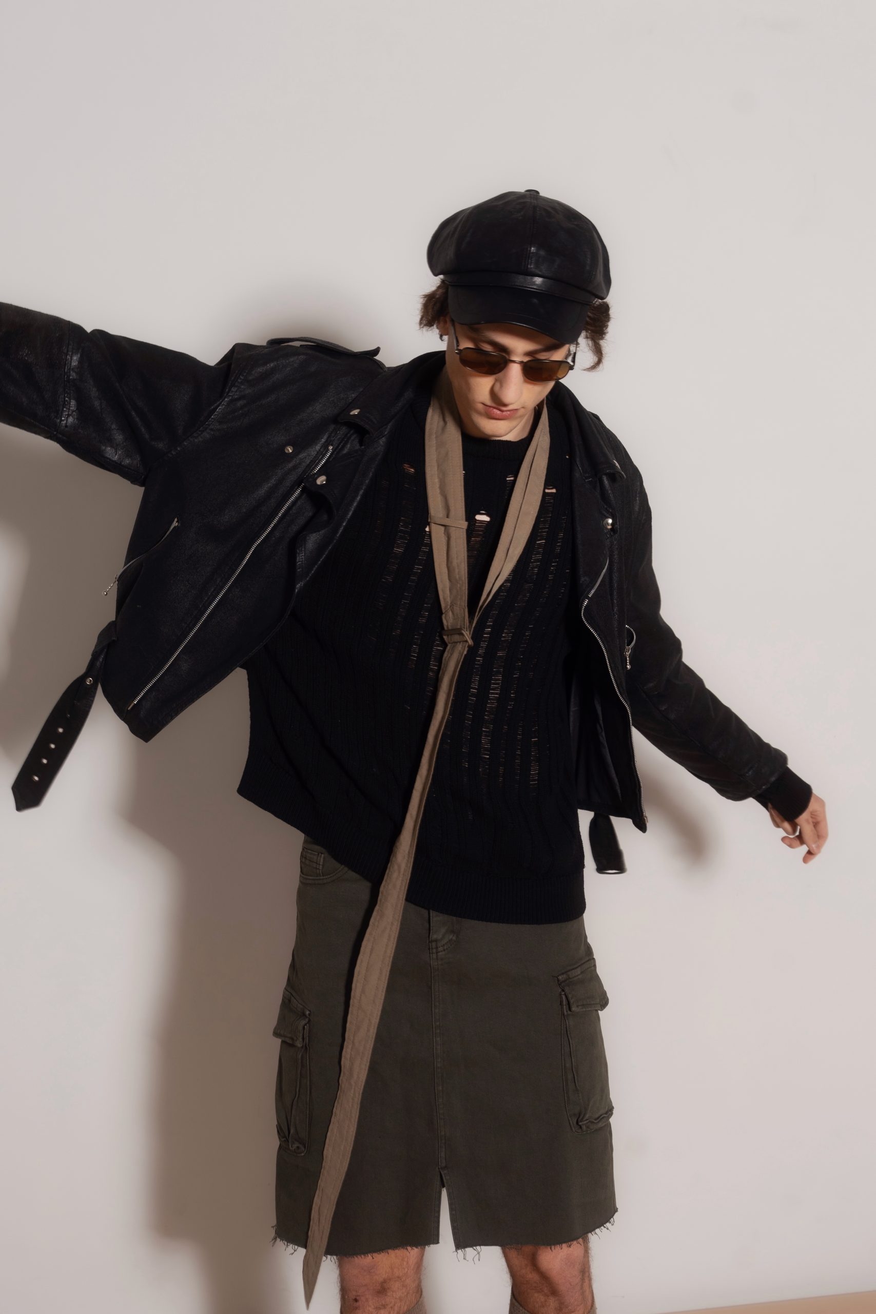 Modello maschile con giacca di pelle nera e occhiali da sole, stile urbano e contemporaneo a Firenze.
