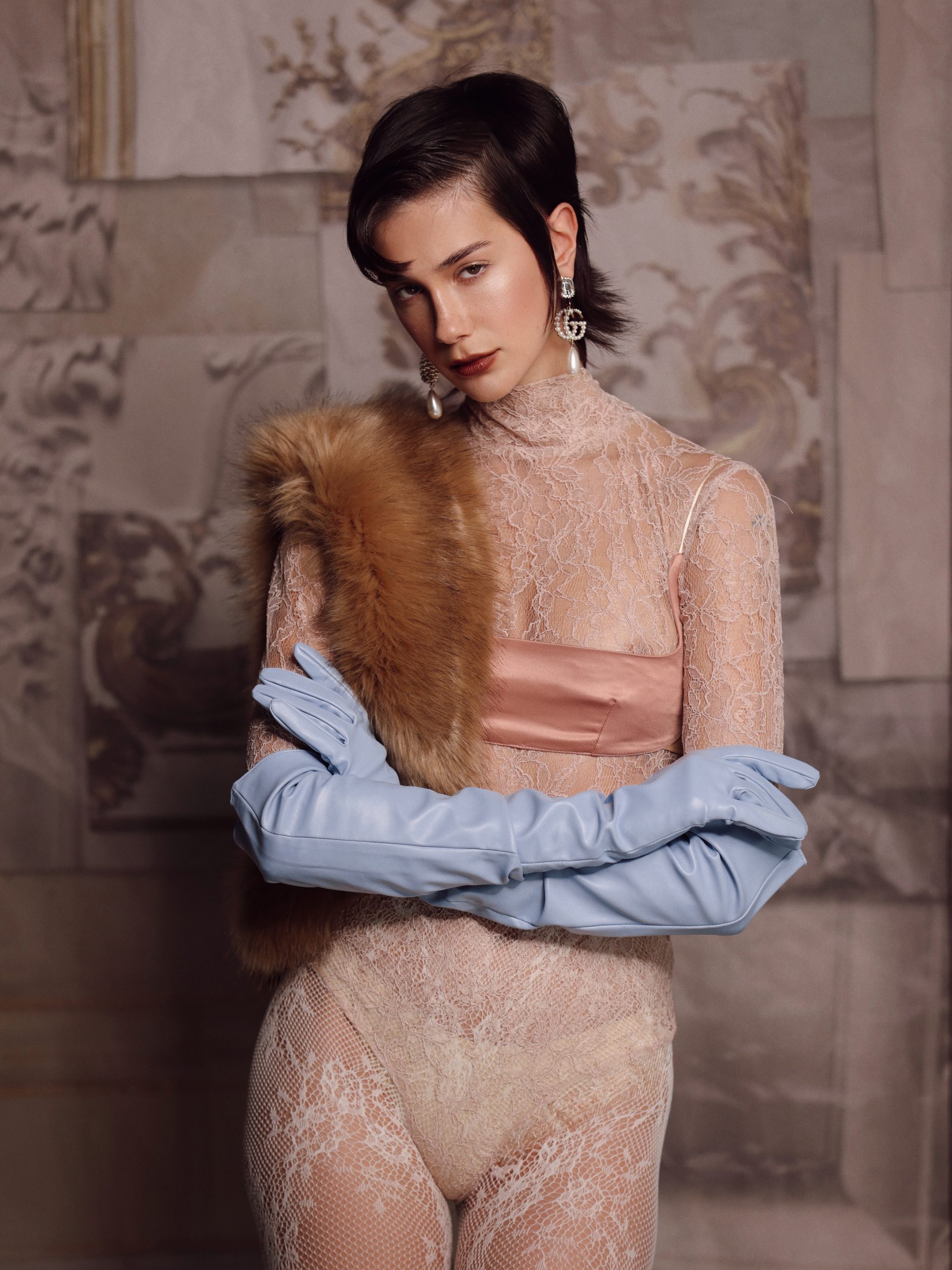 Modella elegante in pizzo con accessori di lusso e guanti blu, moda contemporanea a Firenze.