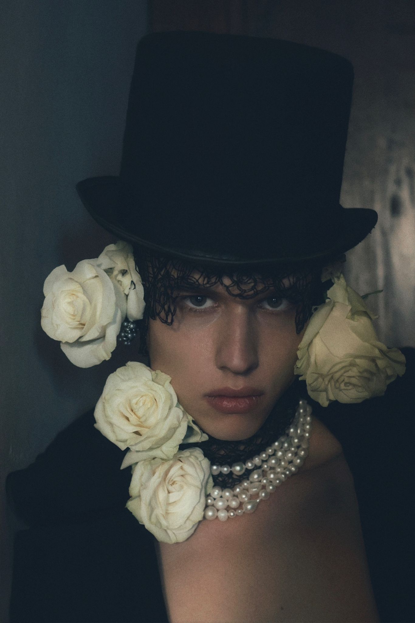 Modella con cappello elegante e rose bianche, ispirazione moda sofisticata e glamour contemporaneo.