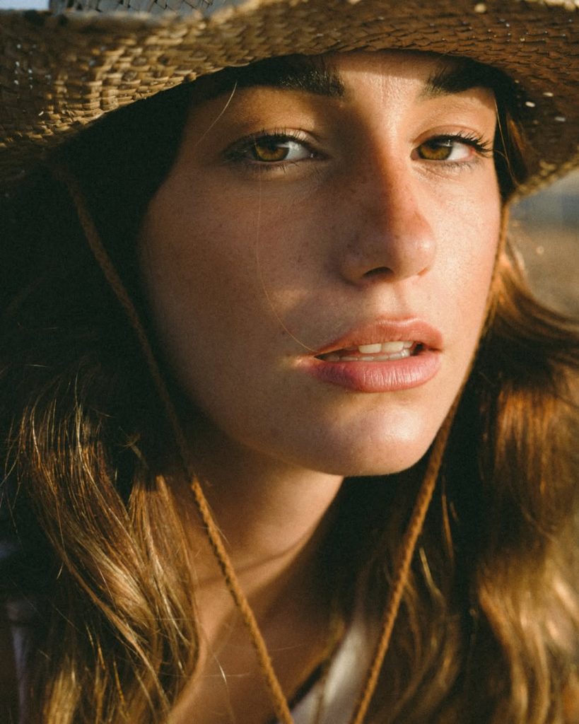 Modella in primo piano con cappello di paglia, parte di un servizio fotografico Fashion Concept a Firenze.
