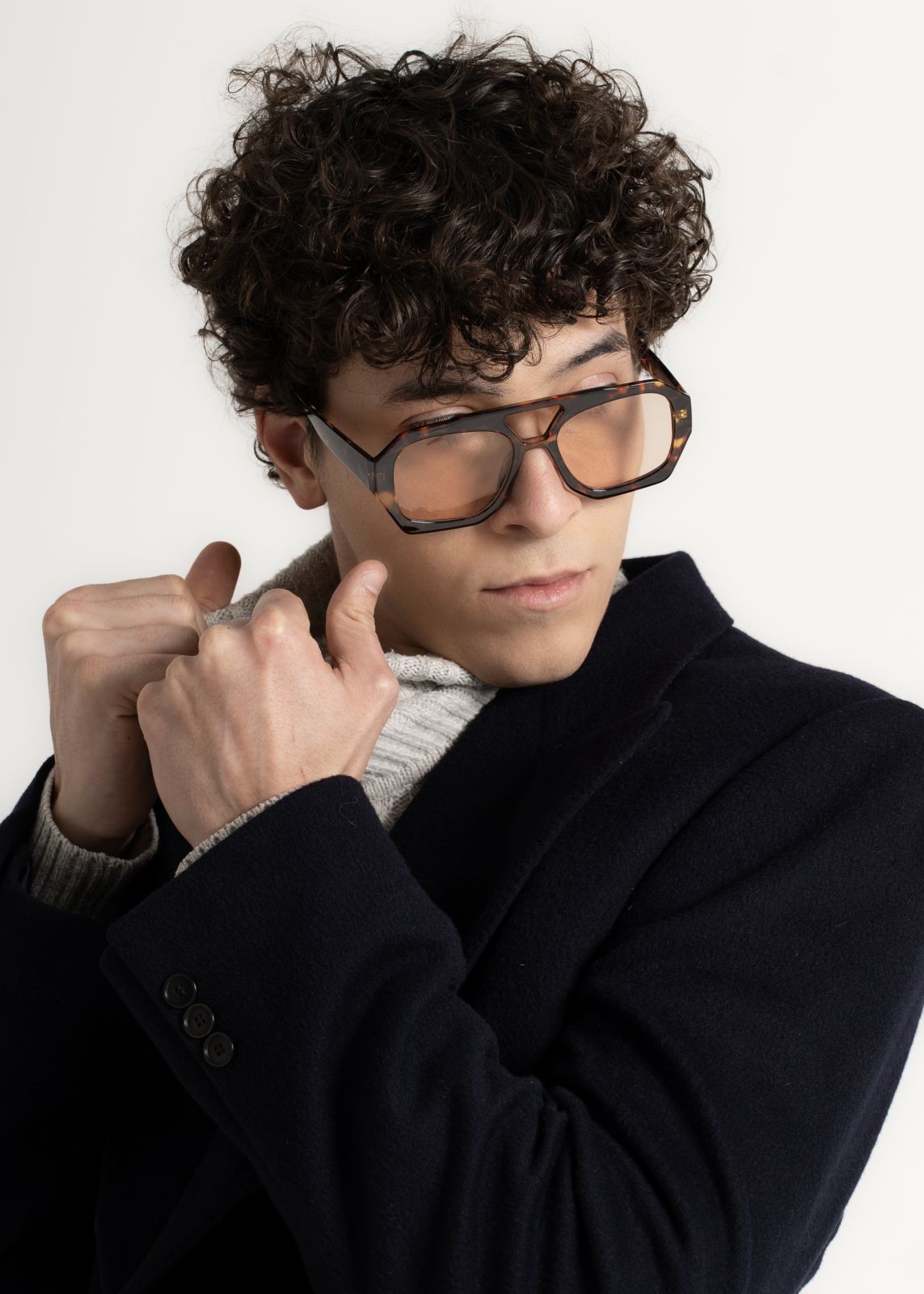 Modello giovane con occhiali alla moda e giacca elegante, stile contemporaneo e qualità sartoriale a Firenze.