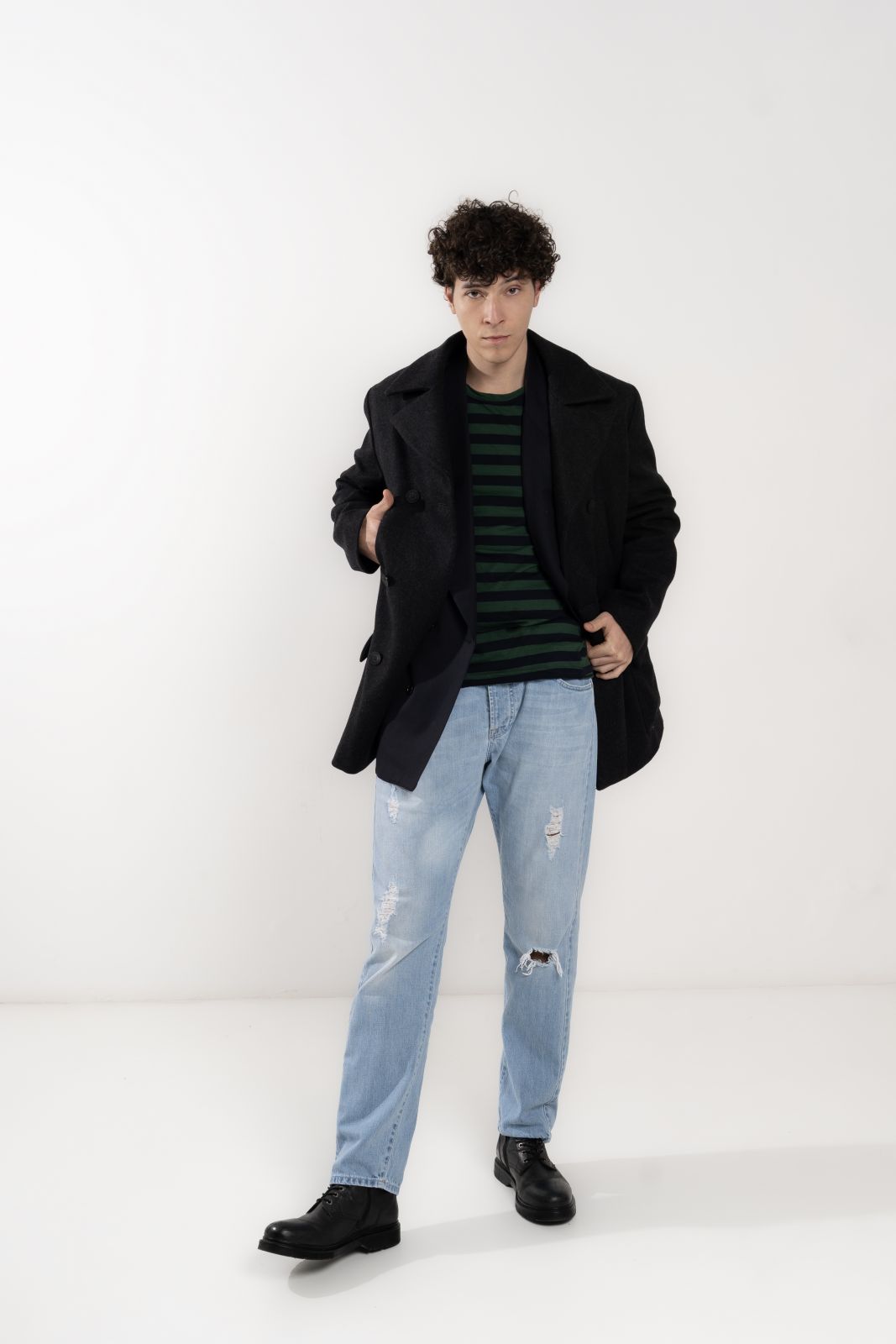 Modello in giacca nera e jeans strappati, look casual e alla moda, shooting a Firenze per Fashion Concept.