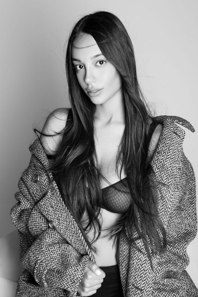 Modella in bianco e nero con giacca elegante, look fashion e capelli lunghi, ideale per campagne di moda.