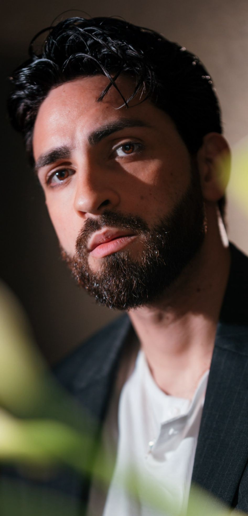 Ritratto di uomo sofisticato con barba, stile elegante e sguardo intenso. Fashion management a Firenze.